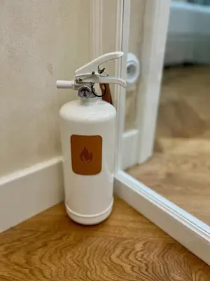 a white fire extinguisher sitting on a table next to a door at Wabi Sabi Nest w/ Garage in Prague