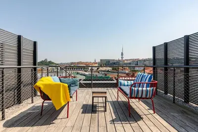 two chairs and a table on a balcony at Wabi Sabi Nest w/ Garage in Prague