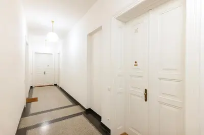 a hallway with white walls and white doors at Wabi Sabi Nest w/ Garage in Prague