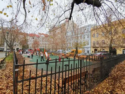 a park in a city with people walking and a fence at AuriApartments Karlín 2KK s terasou a parkováním in Prague
