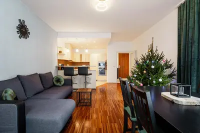 a living room with a couch and a table with a christmas tree at AuriApartments Karlín 2KK s terasou a parkováním in Prague