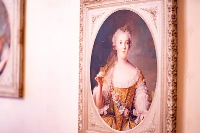 a painting of a woman in a frame on a wall at Extraordinary Prague Apartment in Prague